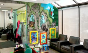 waiting room chairs with forest castle murals behind them and wall mounted kee bee gaming units