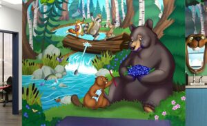 woodland mural of bear eating blueberries and beaver with toothbrush in treatment room