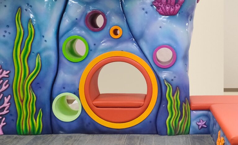 close up of sculpted faux rock wall with built in seating for childrens' hospital