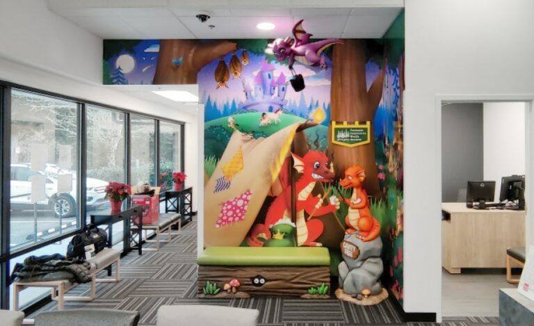 Fairytale themed mural in waiting room with 3D sculpted dragon characters and cladded bench seating.