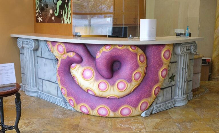 An Atlantis themed reception desk captured by purple octopus tentacles.