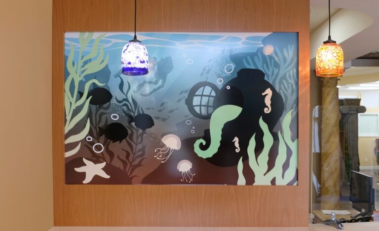 Ocean themed wall mural featuring a diver helmet and fish in an orthodontic office.