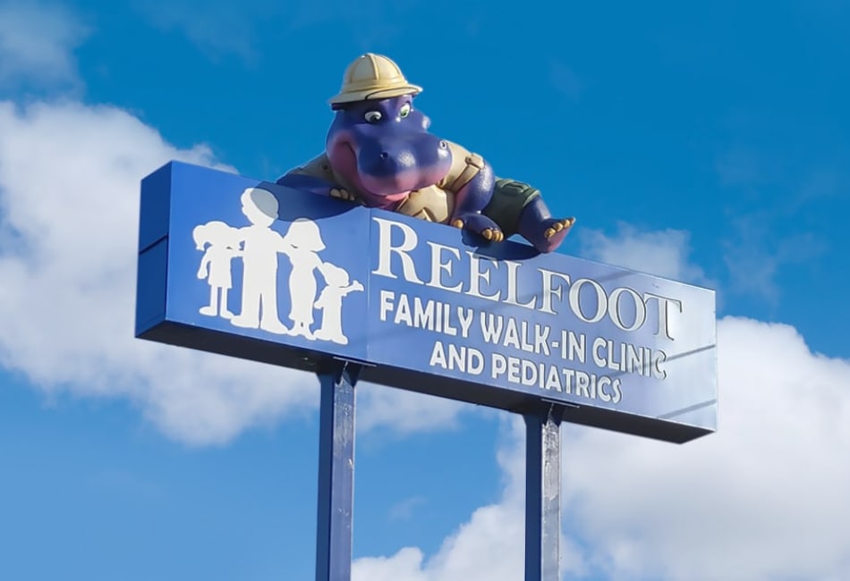 Landmark character of a hippo climbing a business sign.