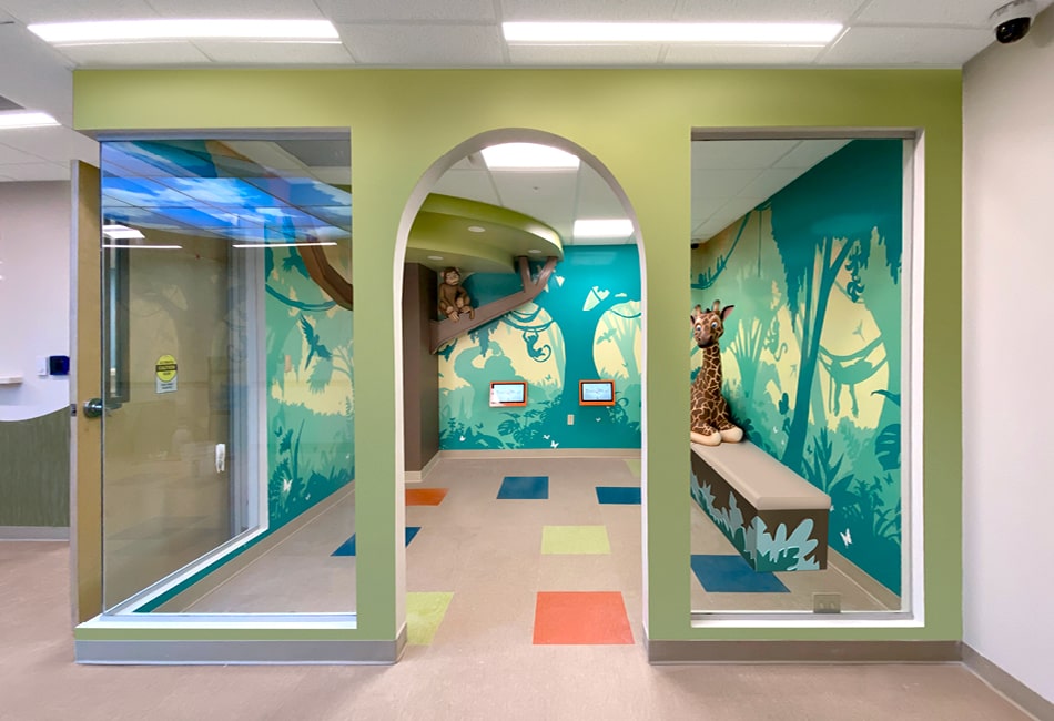 Contemporary jungle themed playroom with wall mounted gaming systems, silhouette murals, and 3D jungle characters.