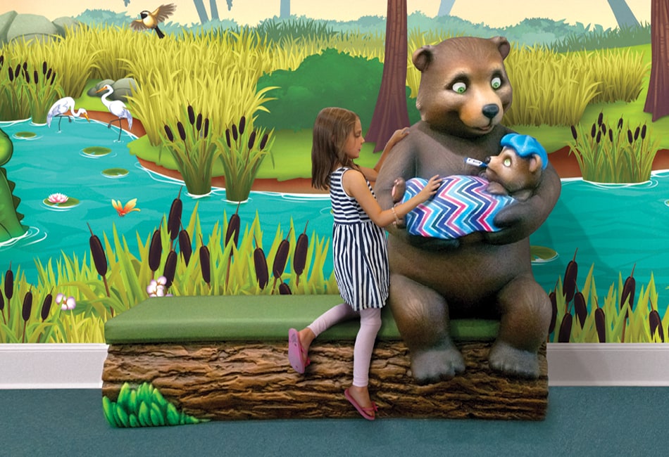 Girl posing with a mom bear and sick baby bear photo opportunity characters.