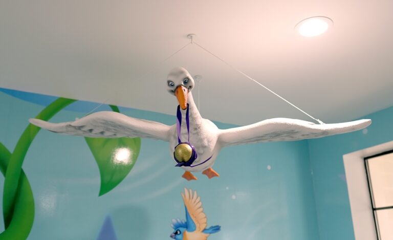 3D sculpted goose from Jack and the Beanstalk flying with a golden egg wrapped in a purple ribbon.