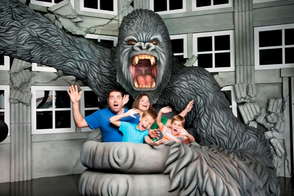 Family posing in the grip of a giant gorilla photo opportunity character.
