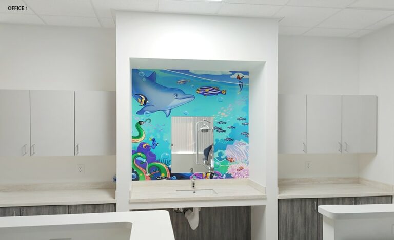 Kid friendly underwater themed mural surrounding mirror at a brushing station.