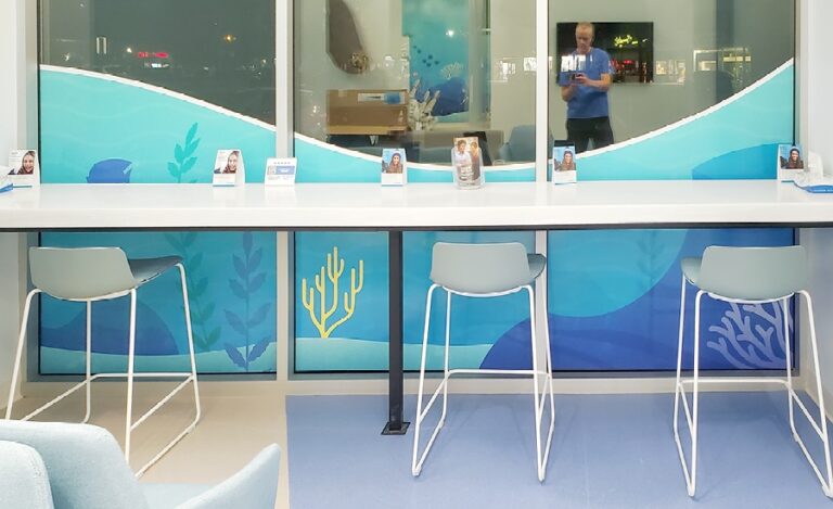 Barstool seating against windows with underwater themed silhouette murals.