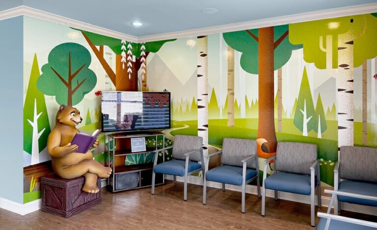 Waiting room with contemporary forest murals and a 3D bear photo op.