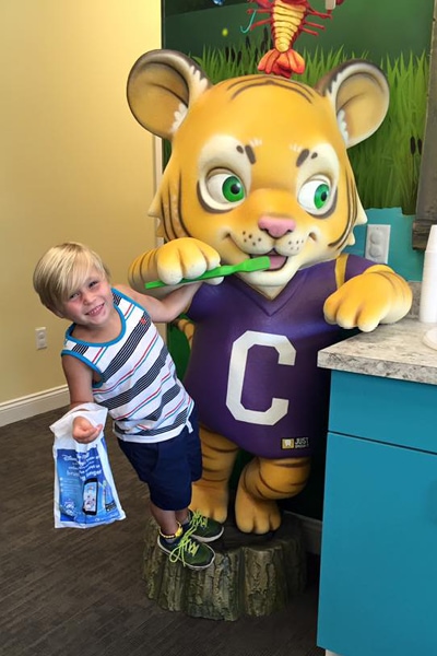 Kid posing with Cubby the photo op tiger.