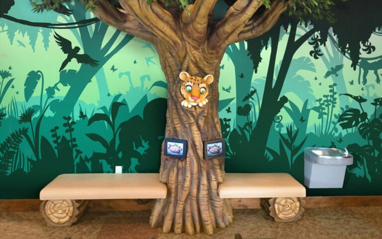 A sculpted jungle tree with gaming tablets and bench seats.