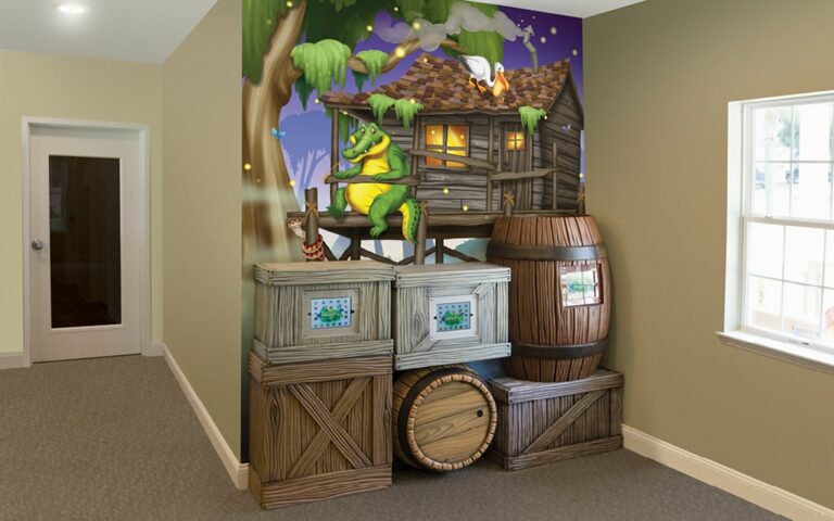 Bayou themed gaming wall with barrels and crates stacked outside a mural of a hut.